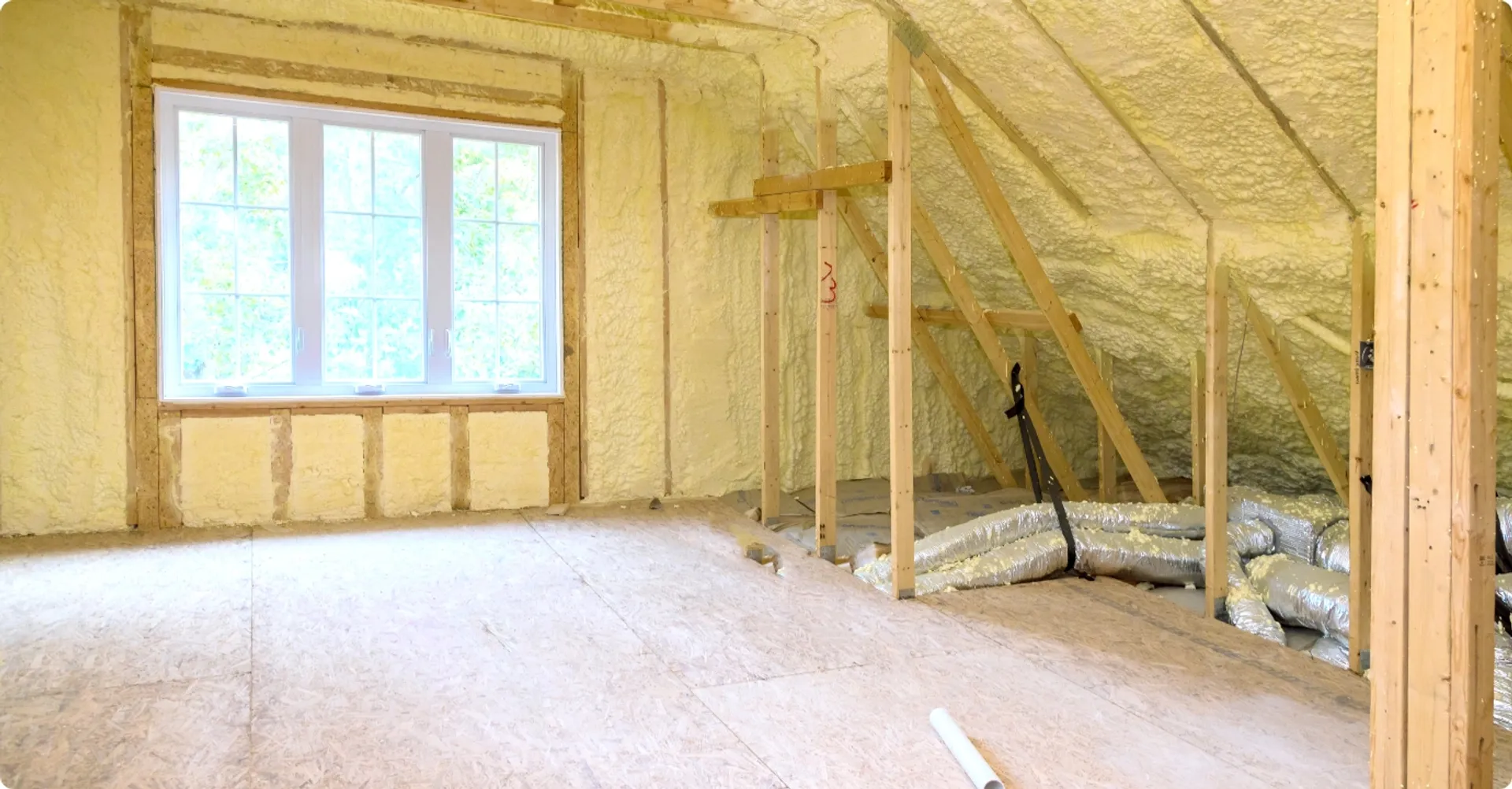 省エネ性能を高めるために断熱材を壁に追加施工している工事現場